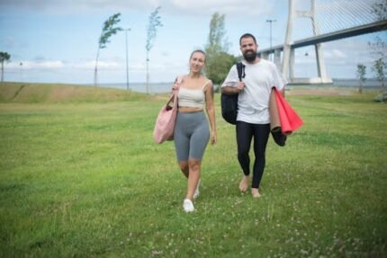Couple walking in Lisbon park with yoga mats, showcasing active lifestyle in natural setting.